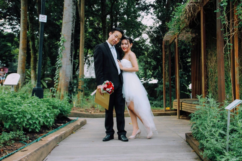 a newly married couple are standing on the wooden walkway