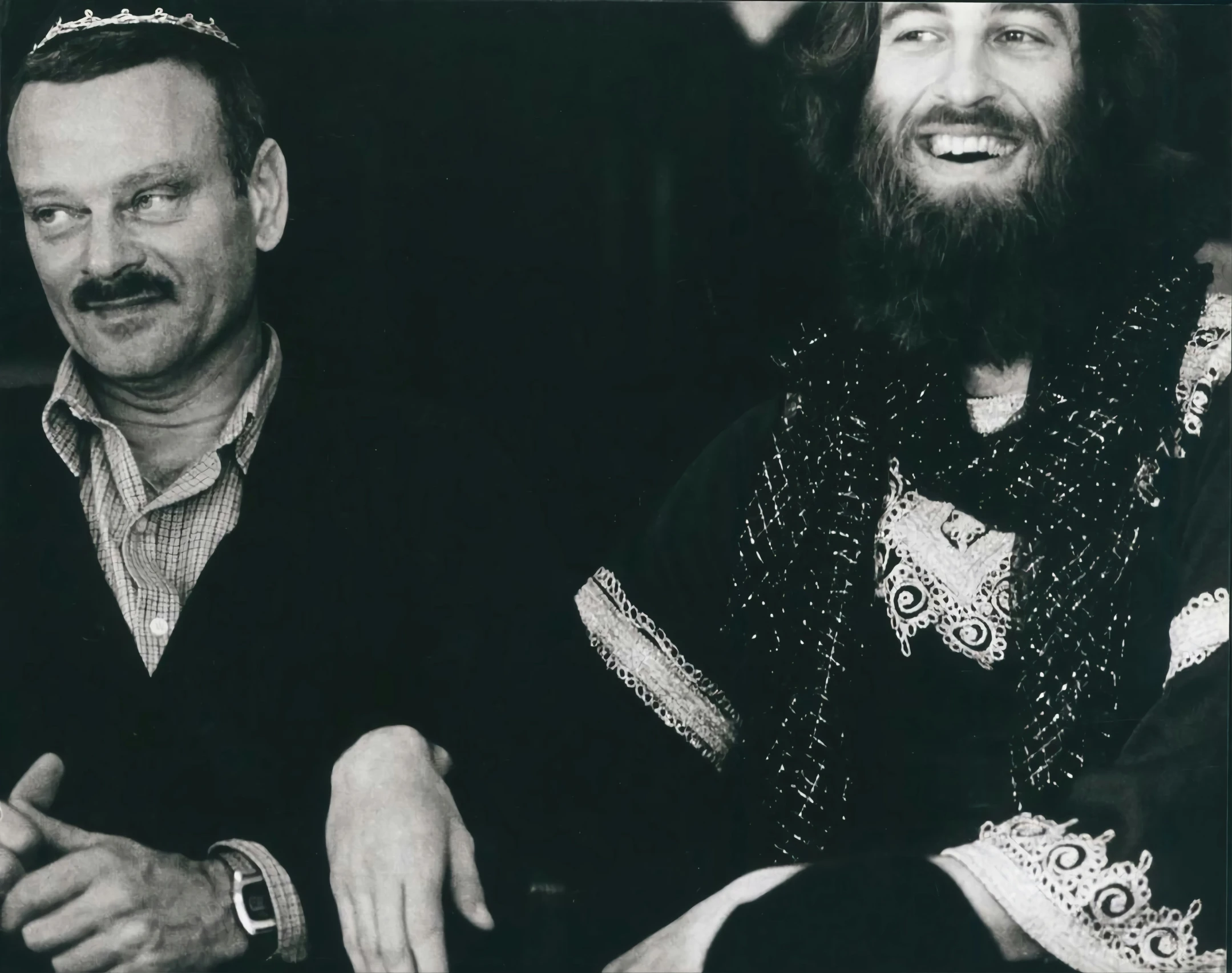 two men sitting and smiling for the camera