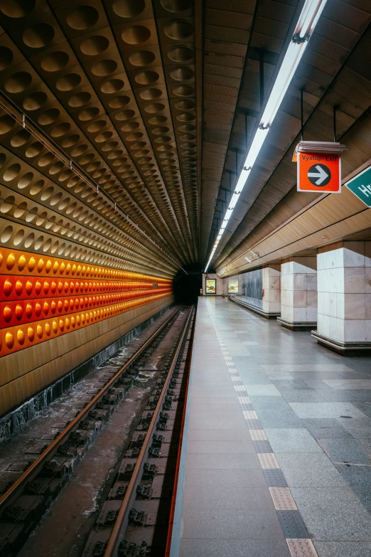 an empty subway station that is next to a platform