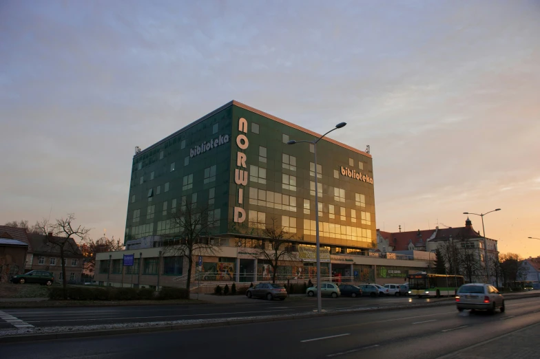 a large green el sits next to a busy road