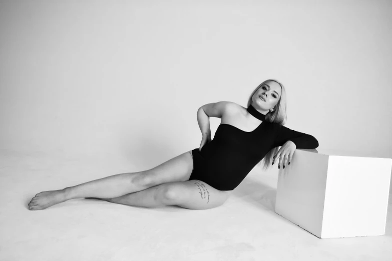 a black and white po of a woman in black clothing on a white backdrop