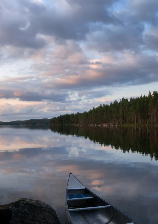 there is a boat on the water and a tree lined shore