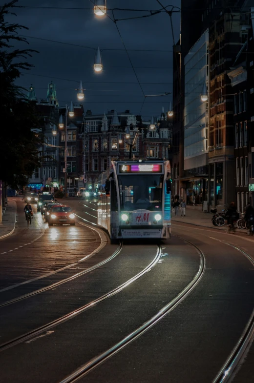 a subway train is coming down the street at night