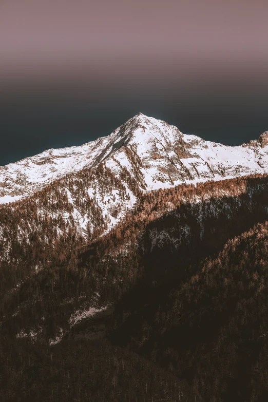 the mountain side view with a brown sky and some snow