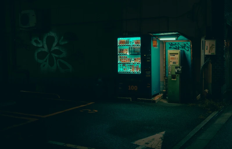 a phone booth with various green items lit up in the dark