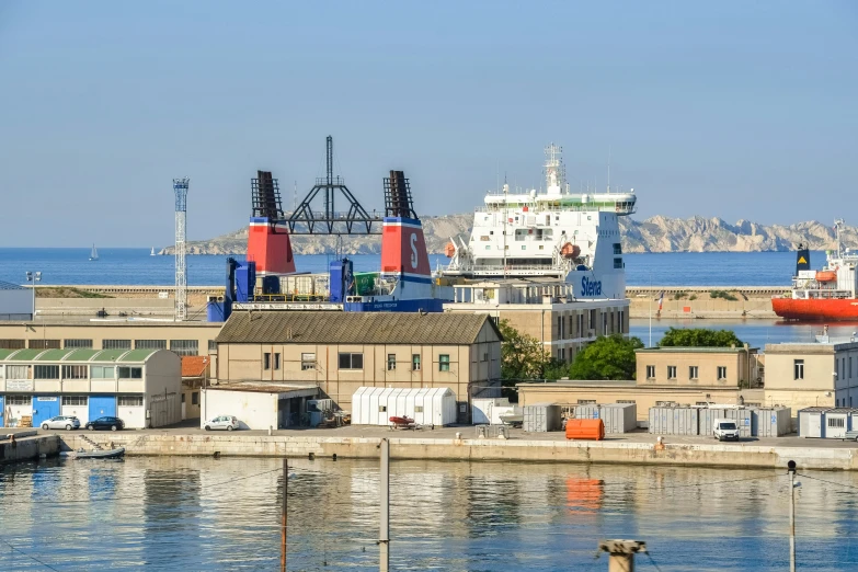 an industrial dock with cargo ships in the distance