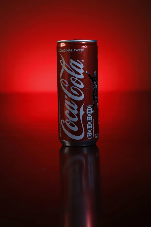 a can of drink sits on a shiny surface