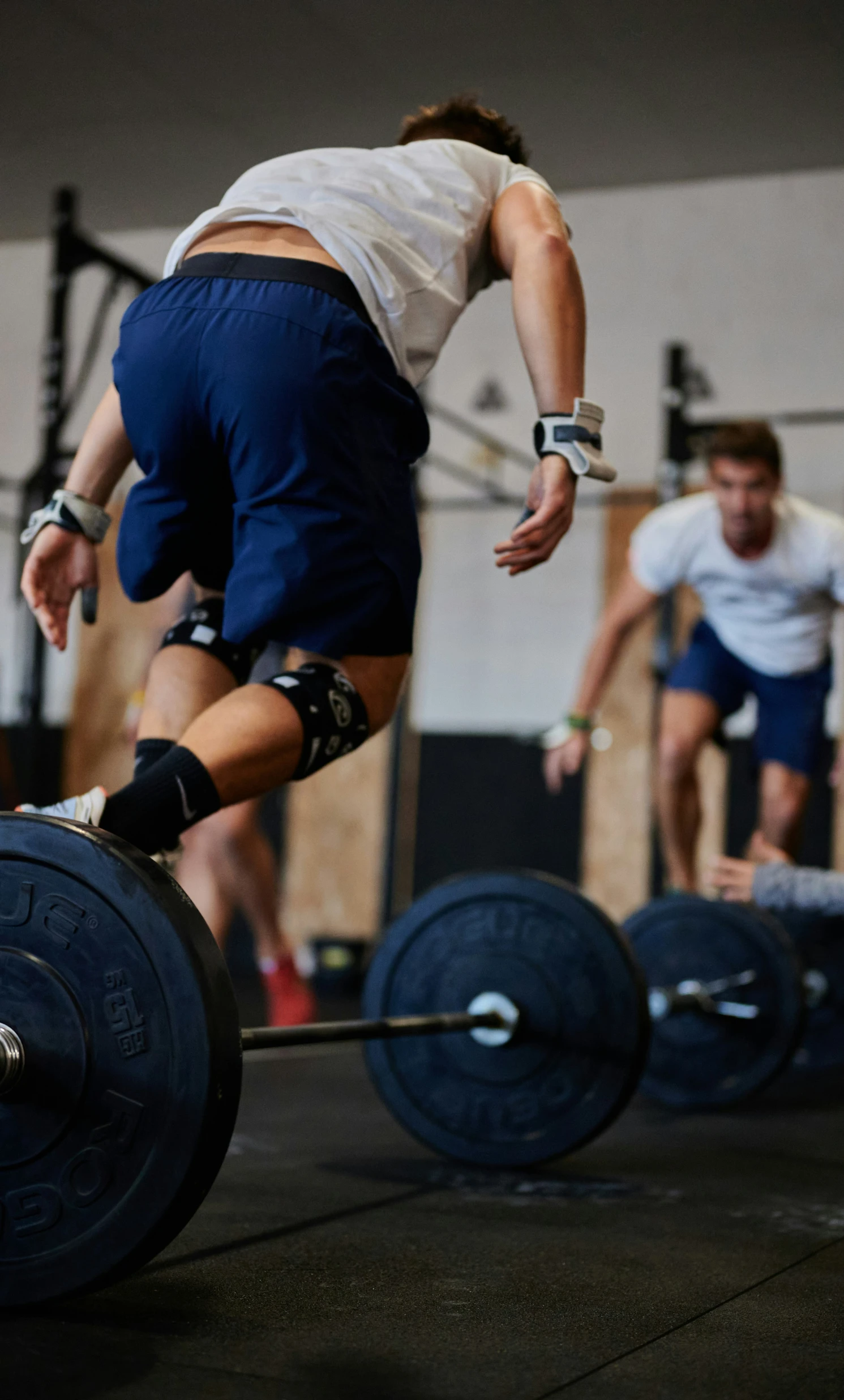 a man is jumping while lifting a barbell