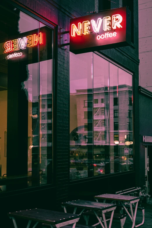 two neon signs above the tables of a cafe