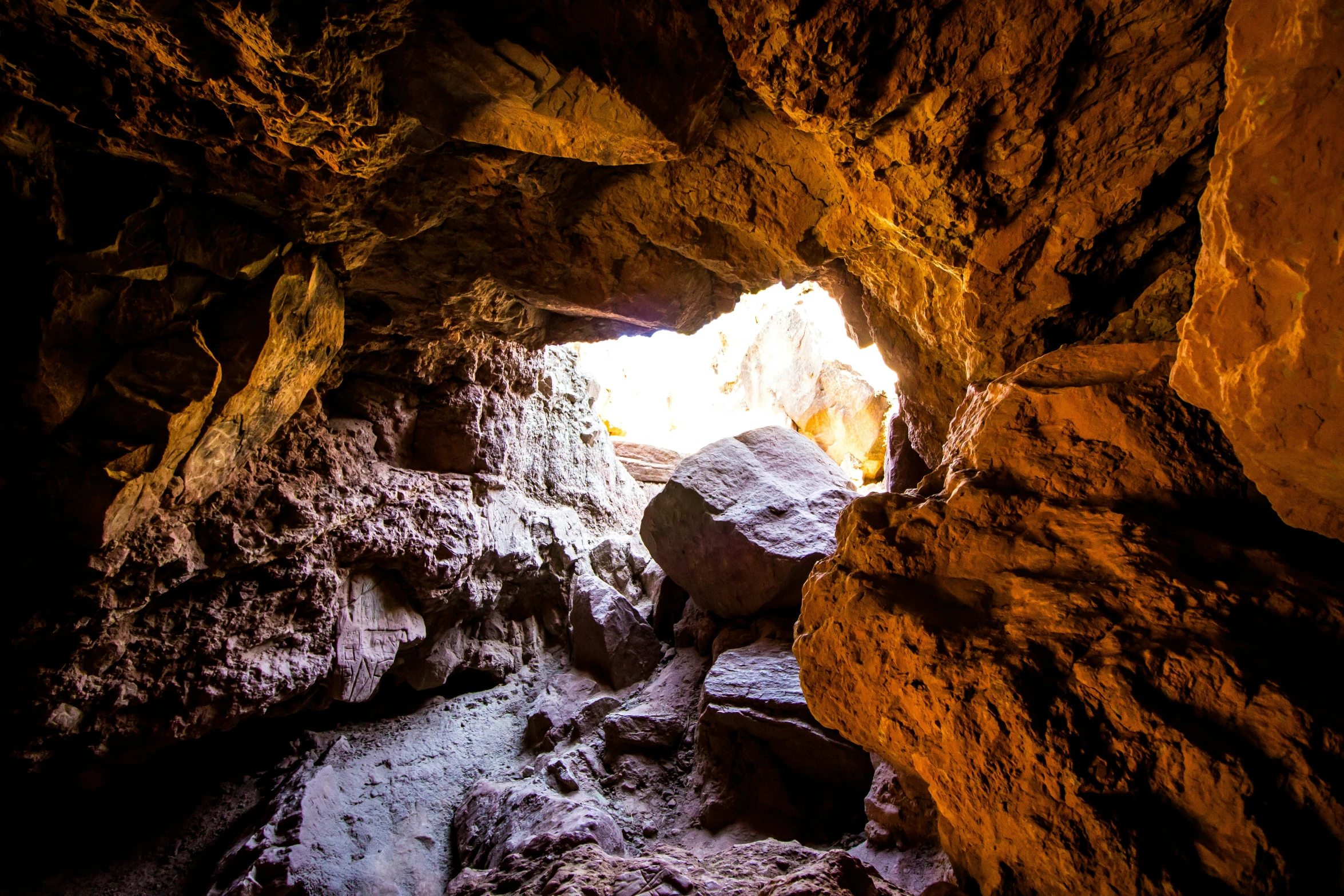 a cave entrance with rocks and snow