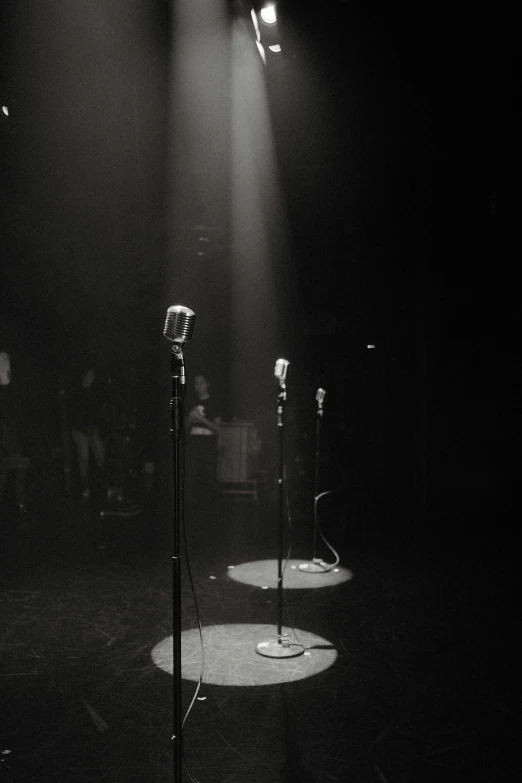 three microphones in the dark on stage