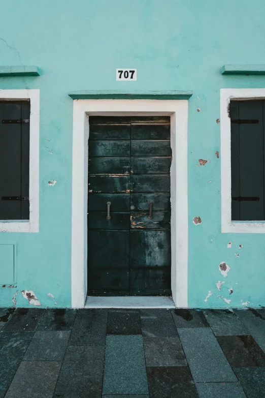 an apartment building with two black double doors and number 707