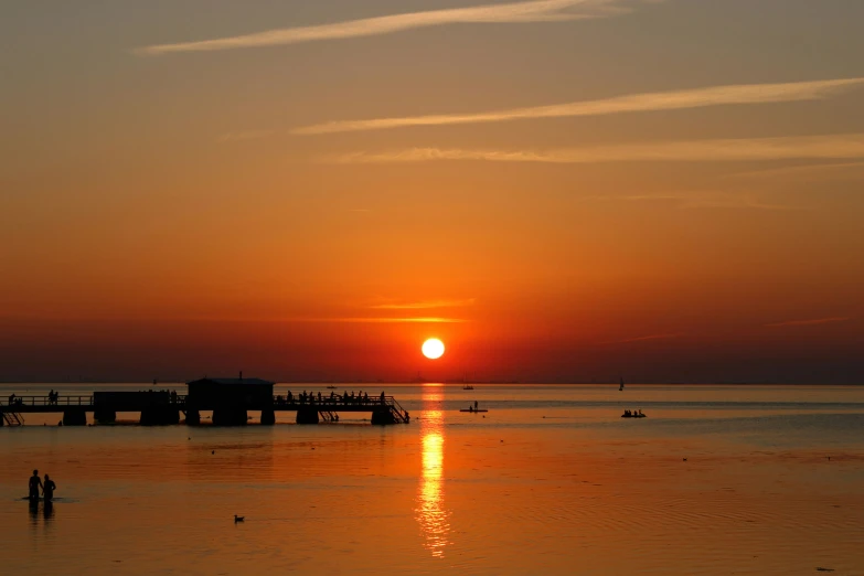 sunset over the ocean with many boats in water