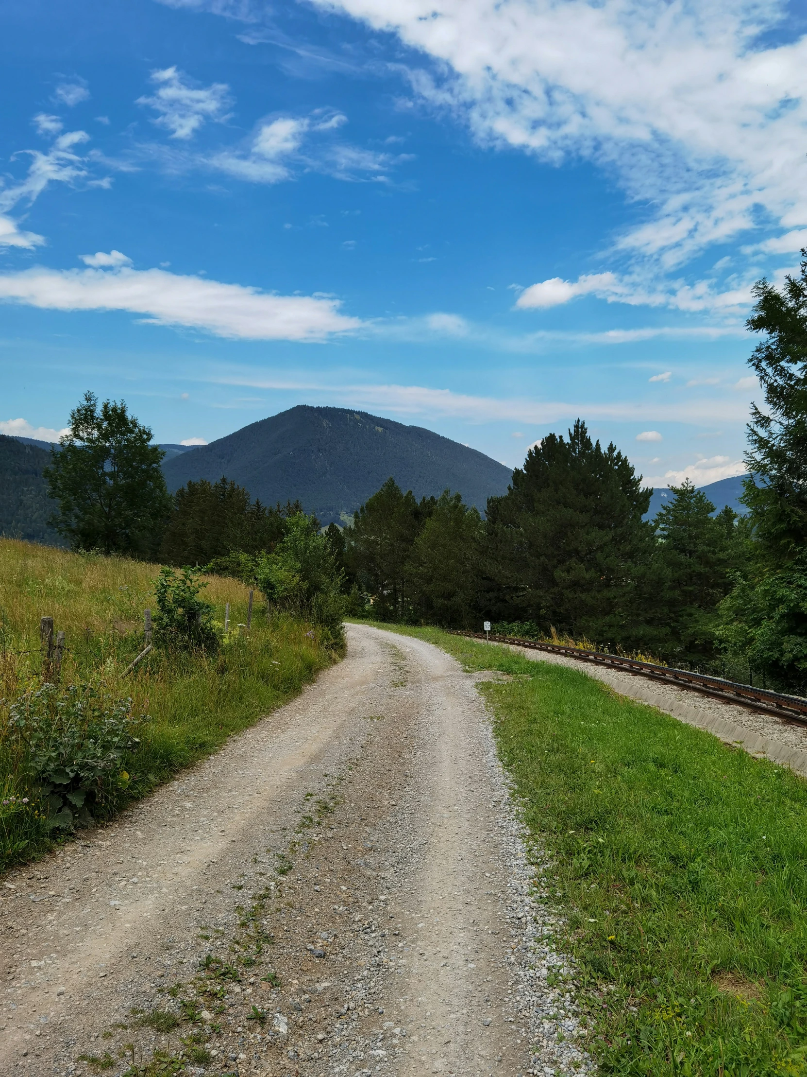 an asphalt road running through the grassy hills