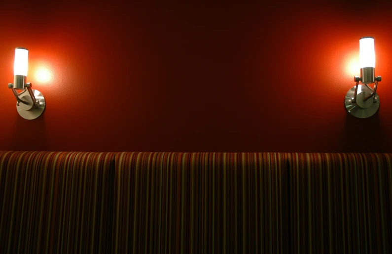 two lights that are lit up on a wall