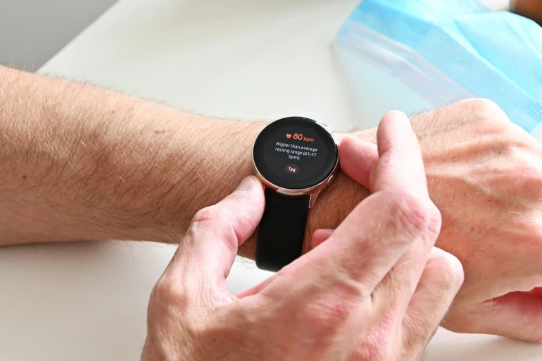 a person holding an electronic watch over a table