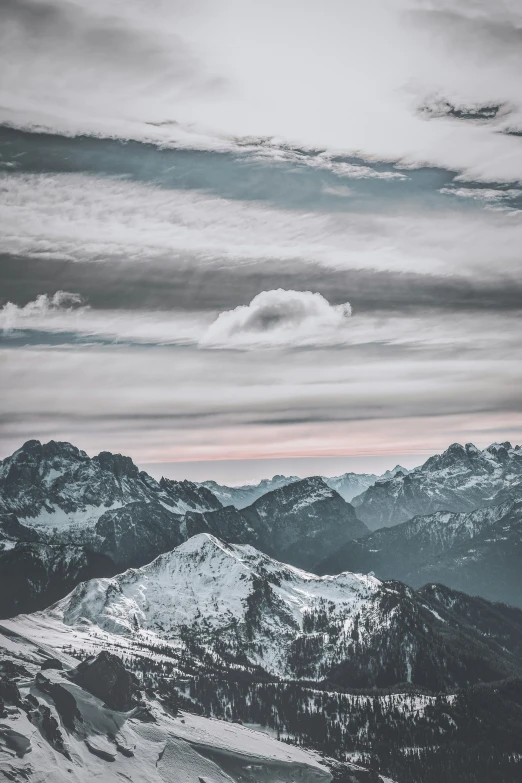 a snow - covered mountain range with mountains in the distance