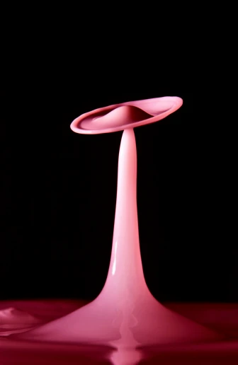 a pink vase sitting on top of a table