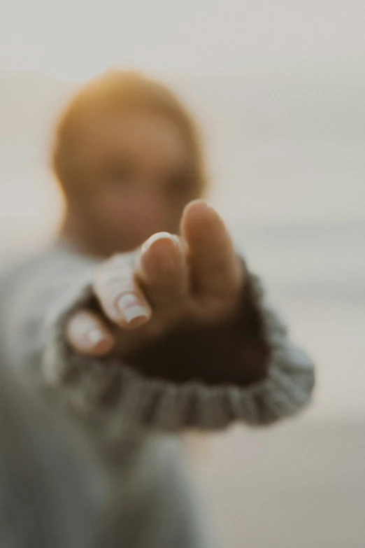 a blurry image of a baby holding soing with his hand