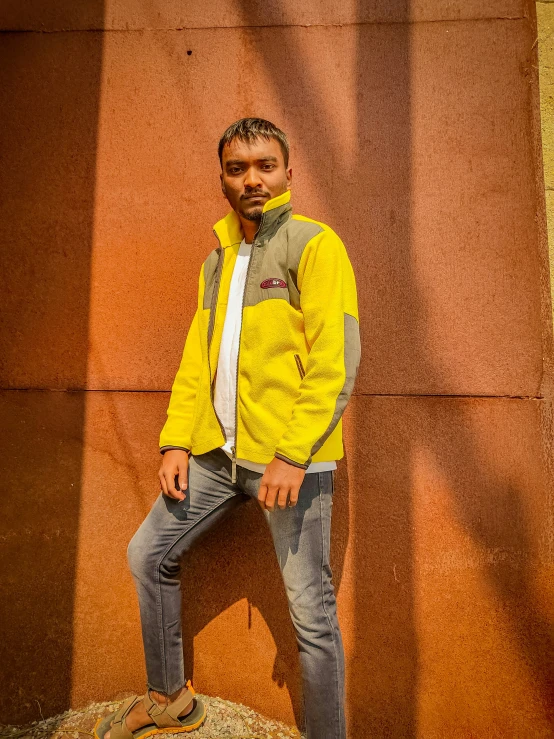 an indian man in yellow jacket poses for the camera