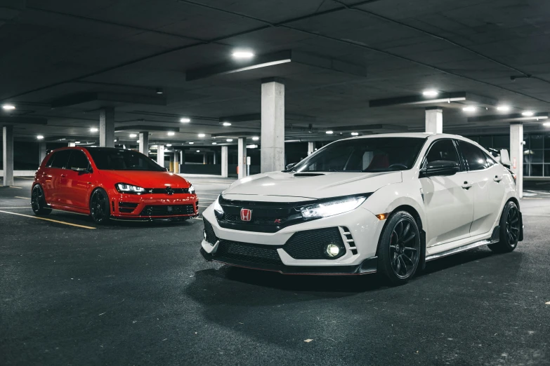 two white and red cars sit in a parking garage