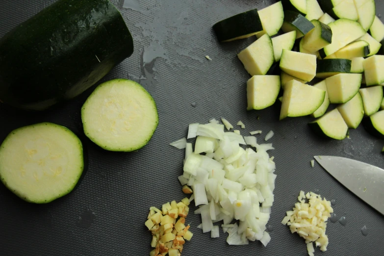 zucchini and chopped vegetables with two knives next to them