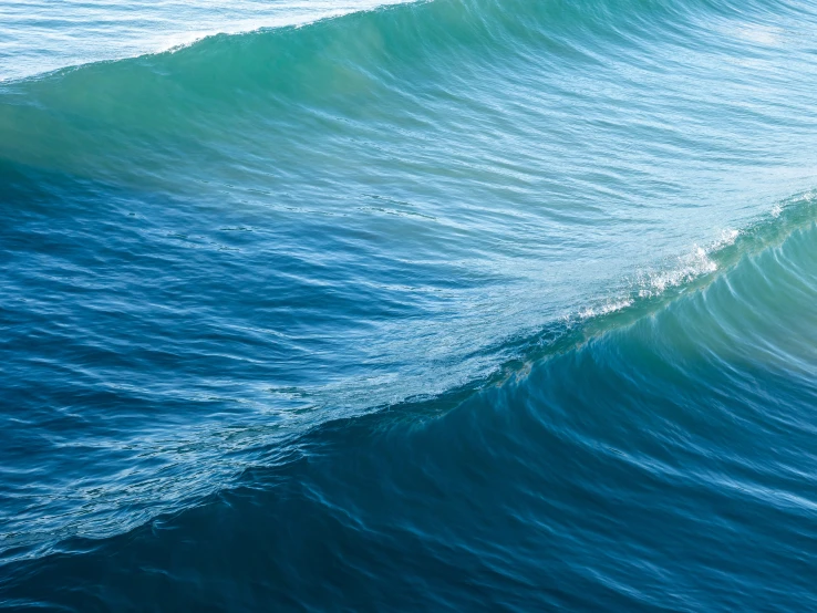 an ocean wave breaking and rolling over a boat