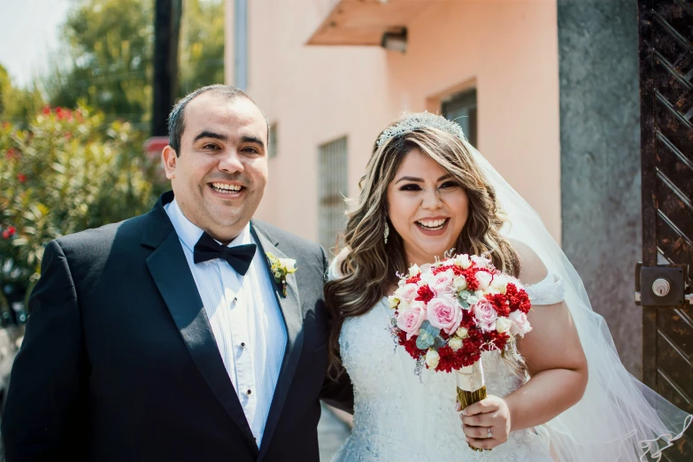 the groom poses with his bride on their wedding day