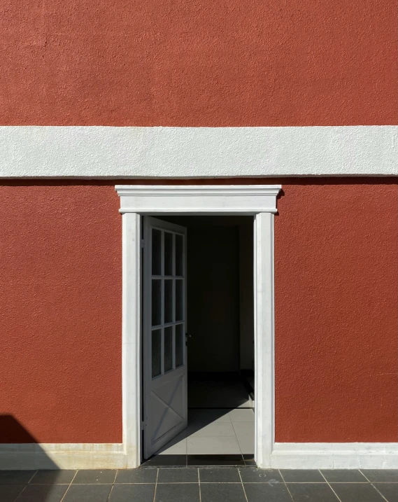 open door with red stucco wall in an alley