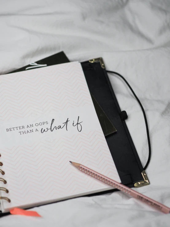 a notebook with writing on it sits on a bed