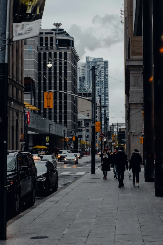 people are walking down the street in between some buildings