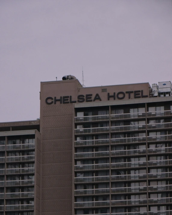 a tall brown building with windows and an advertit on it