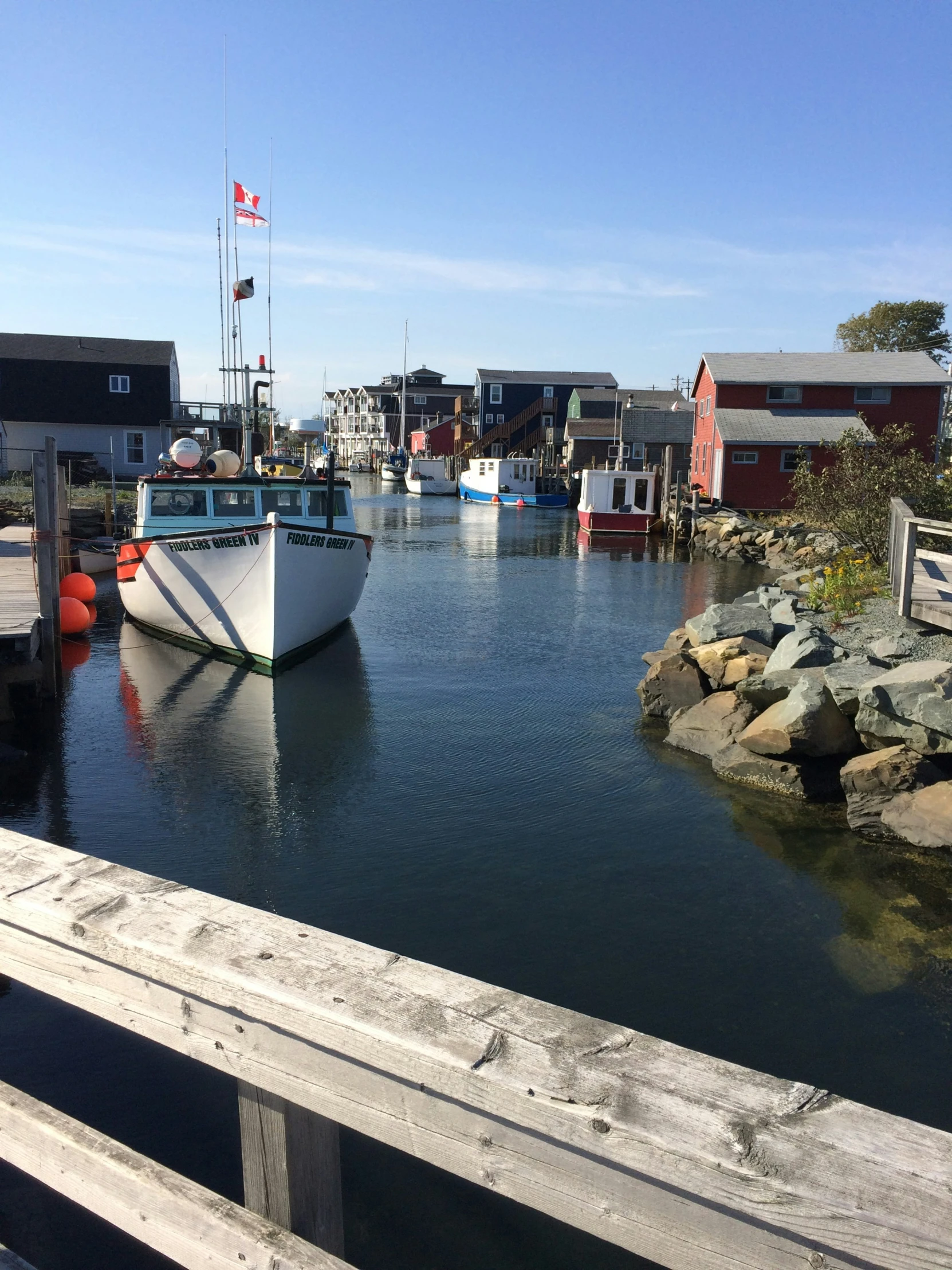 boats sitting in the water next to a shore line