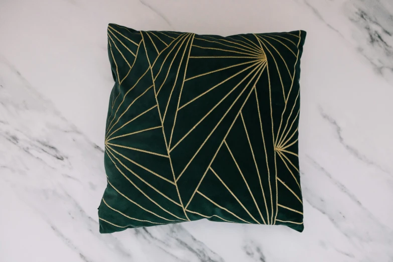 a green cushion with gold triangles on it