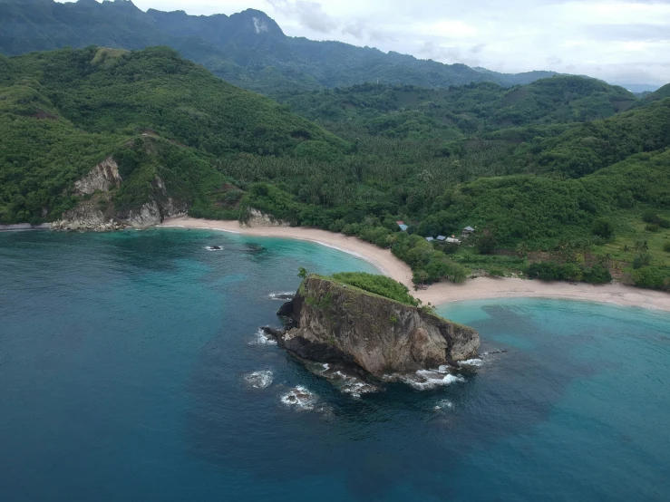 an aerial view of the ocean with a small island