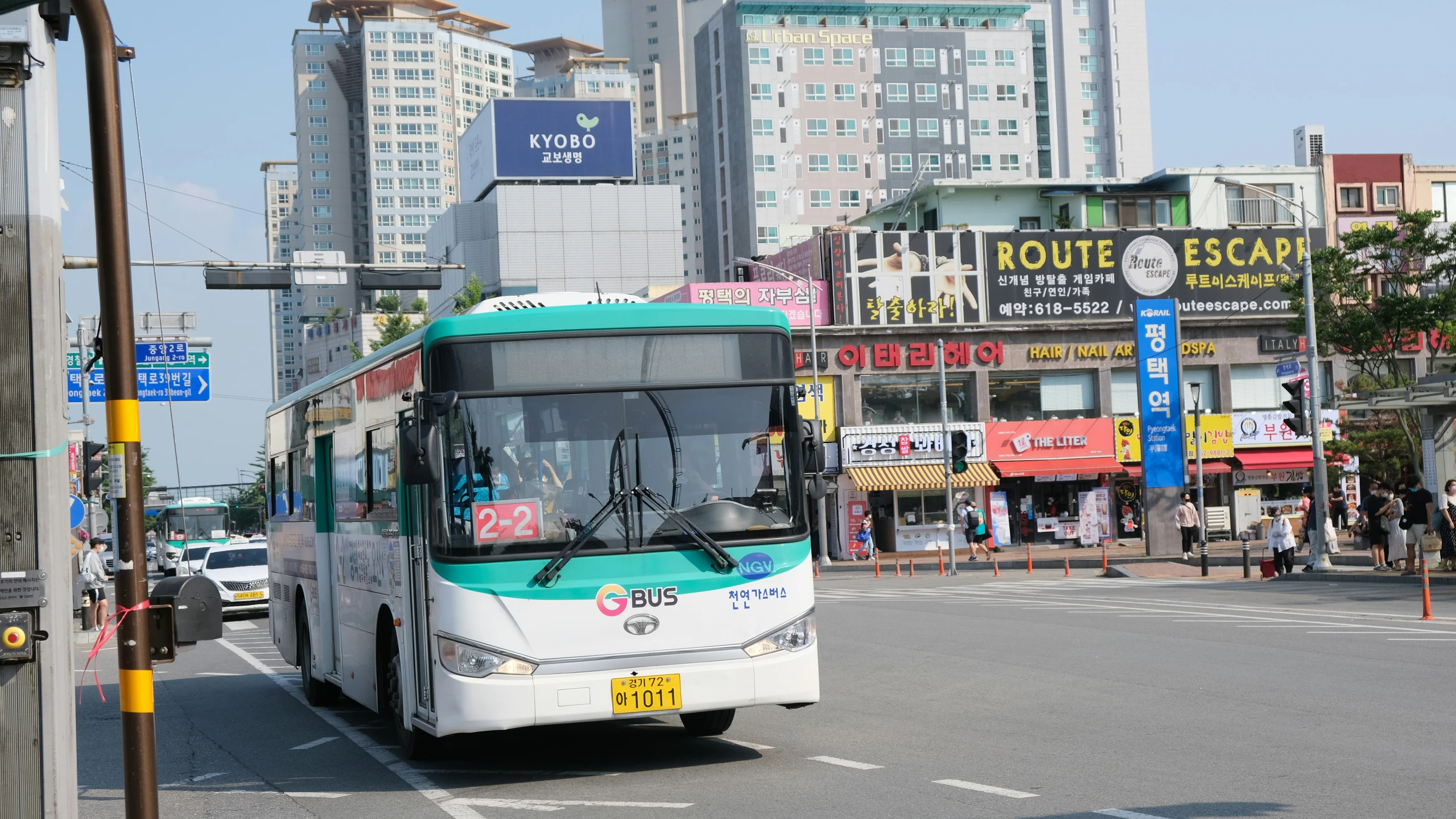 a public transit bus with a green roof driving down a street