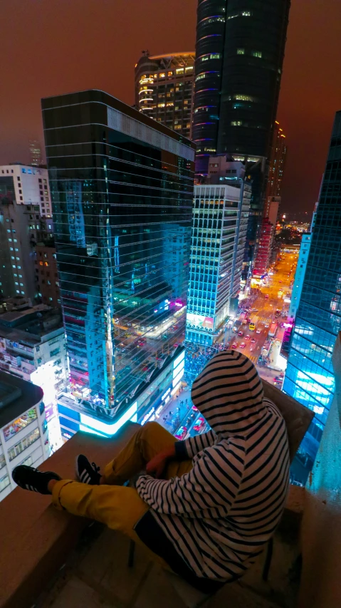 a person sitting on top of a roof looking at soing