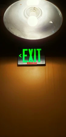 a neon exit sign at an exit door