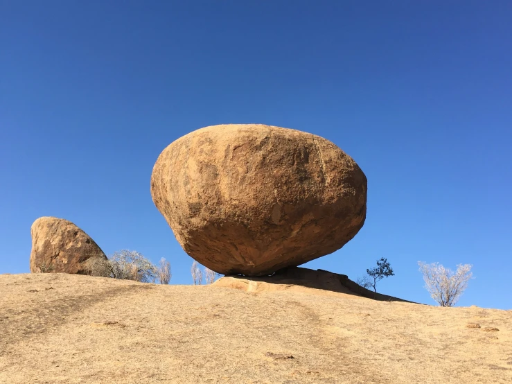 a large stone sitting in the middle of a desert