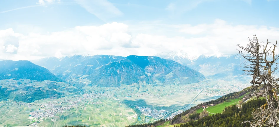 mountains and valleys covered in trees, on a sunny day