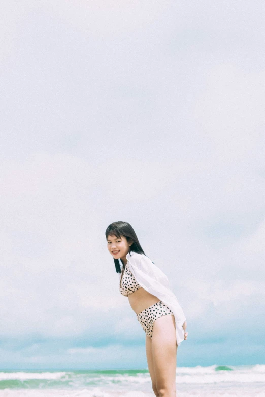 a girl posing on the beach in a leopard swim suit