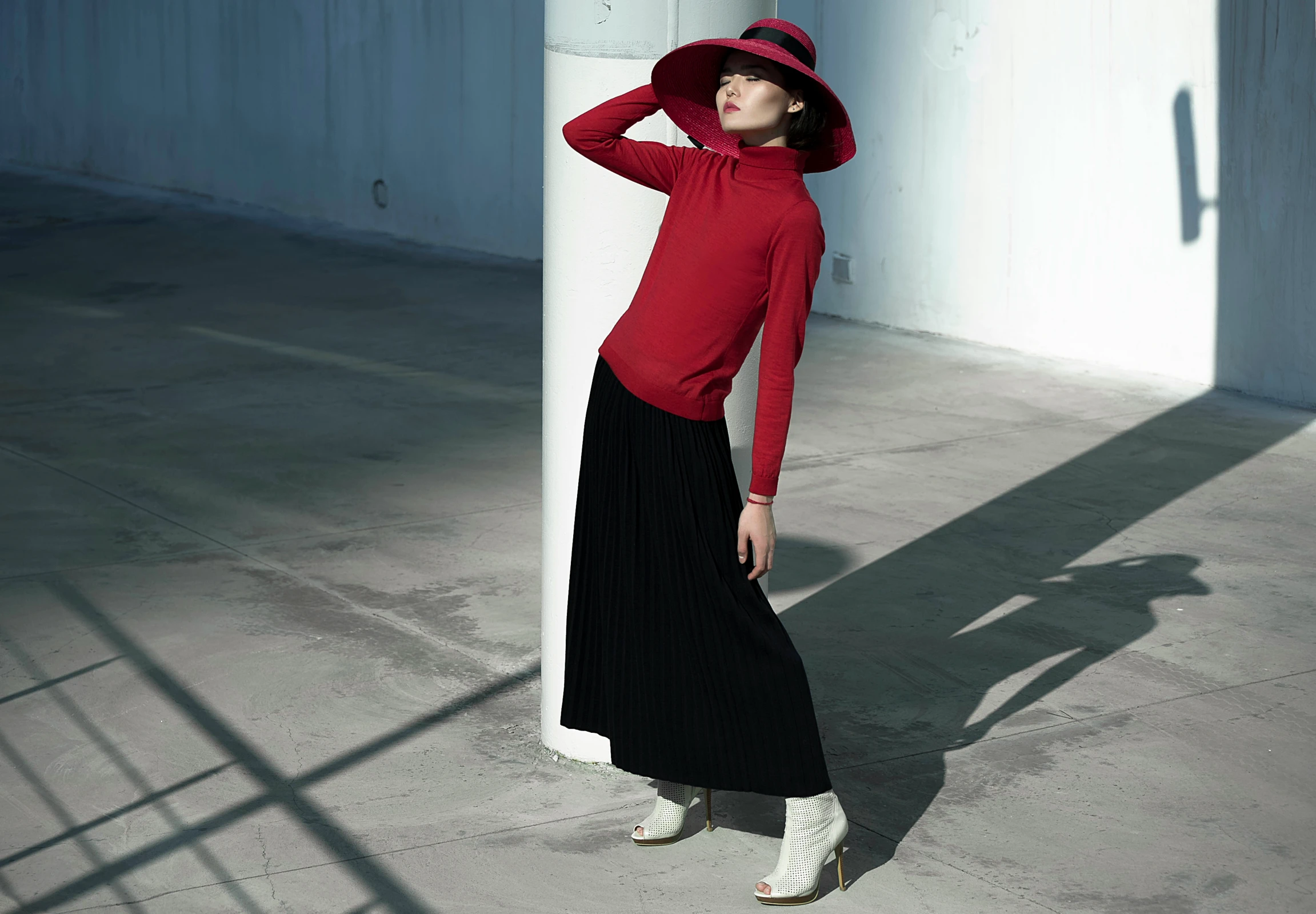 a woman in red is standing near a column