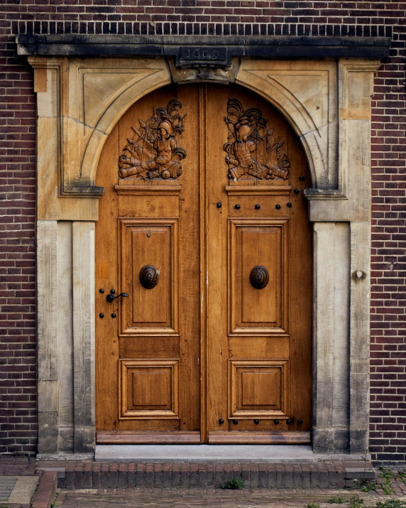 there is a tall brick building with two large wood doors