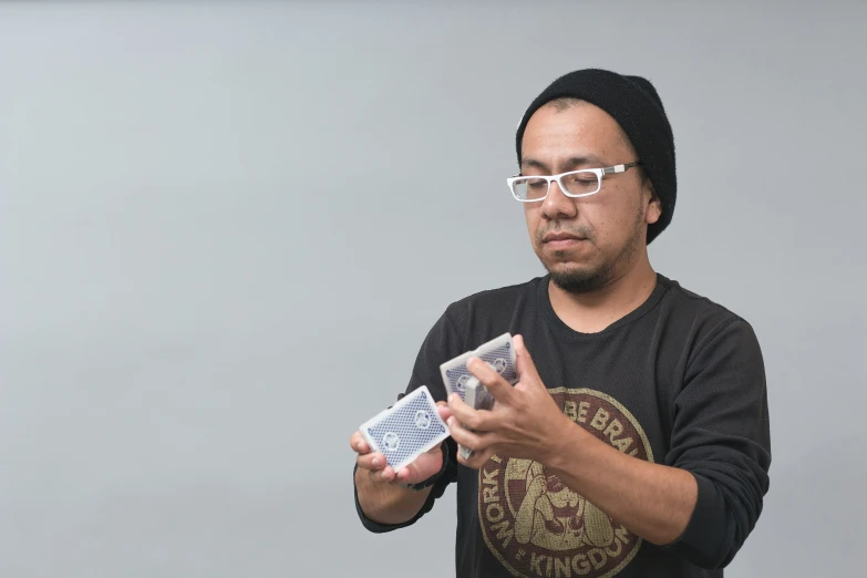 a man with glasses standing holding onto an item