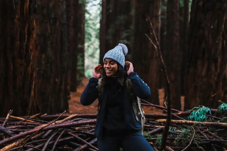 the young woman is wearing a beanie while listening to her mp3 player