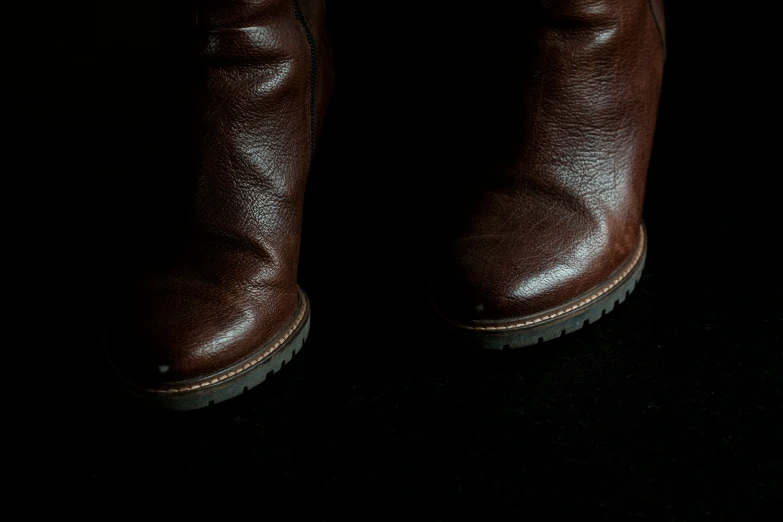 a pair of brown shoes that is in the dark