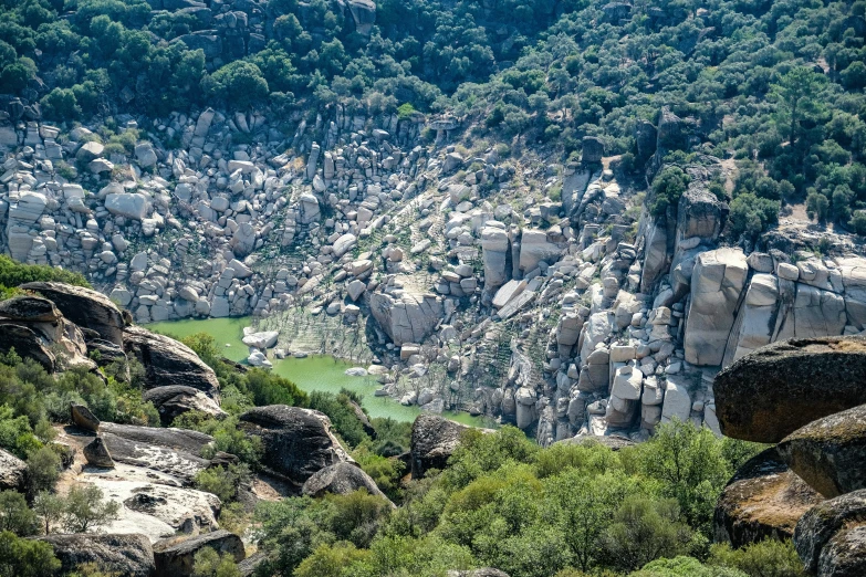 large rocks and vegetation near a valley covered with trees