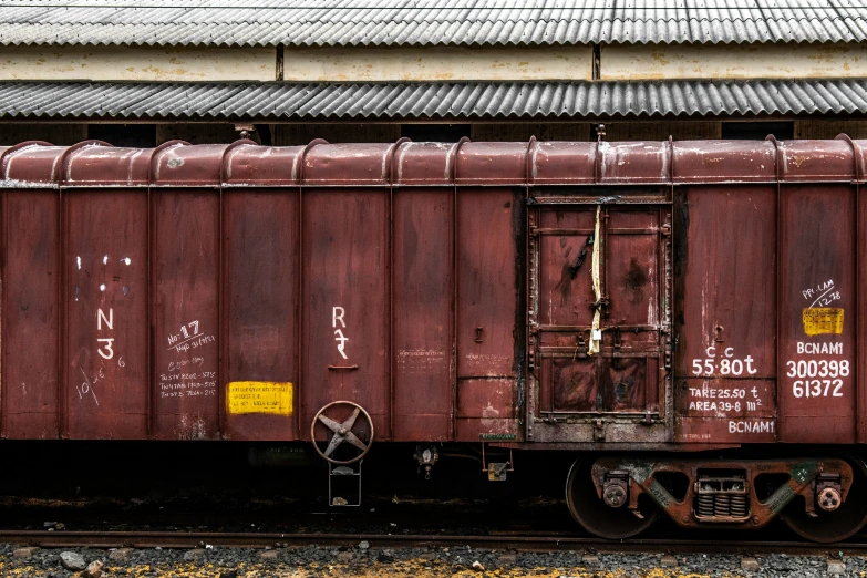 a rusty, red train car is sitting in the railroad