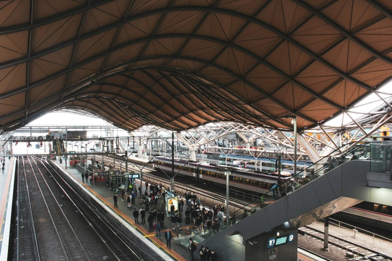 a train station has many platforms and people waiting