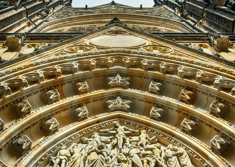 the top of a very tall cathedral with statues on it